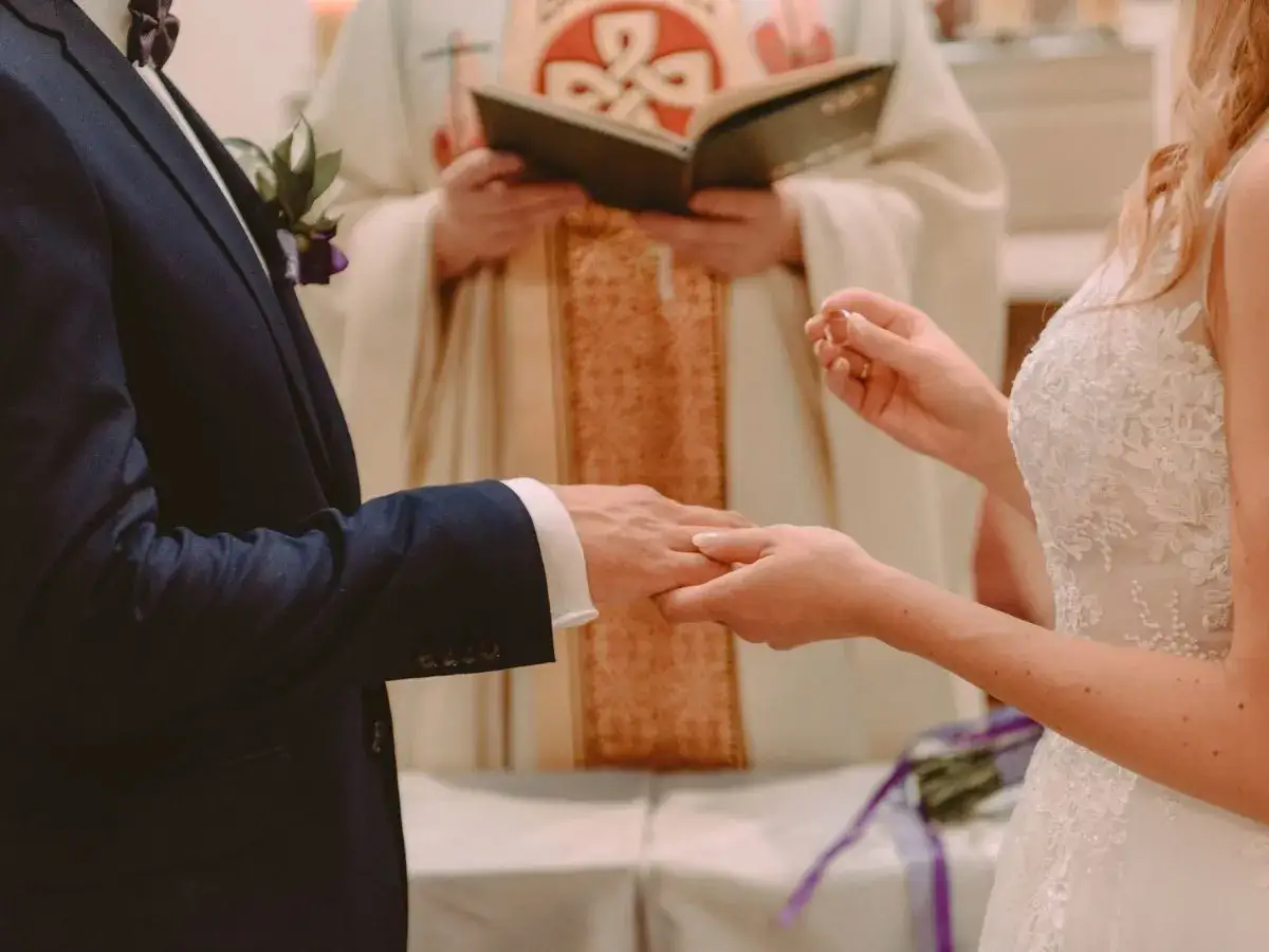 Para ślubna wymienia obrączki podczas ceremonii w kościele.