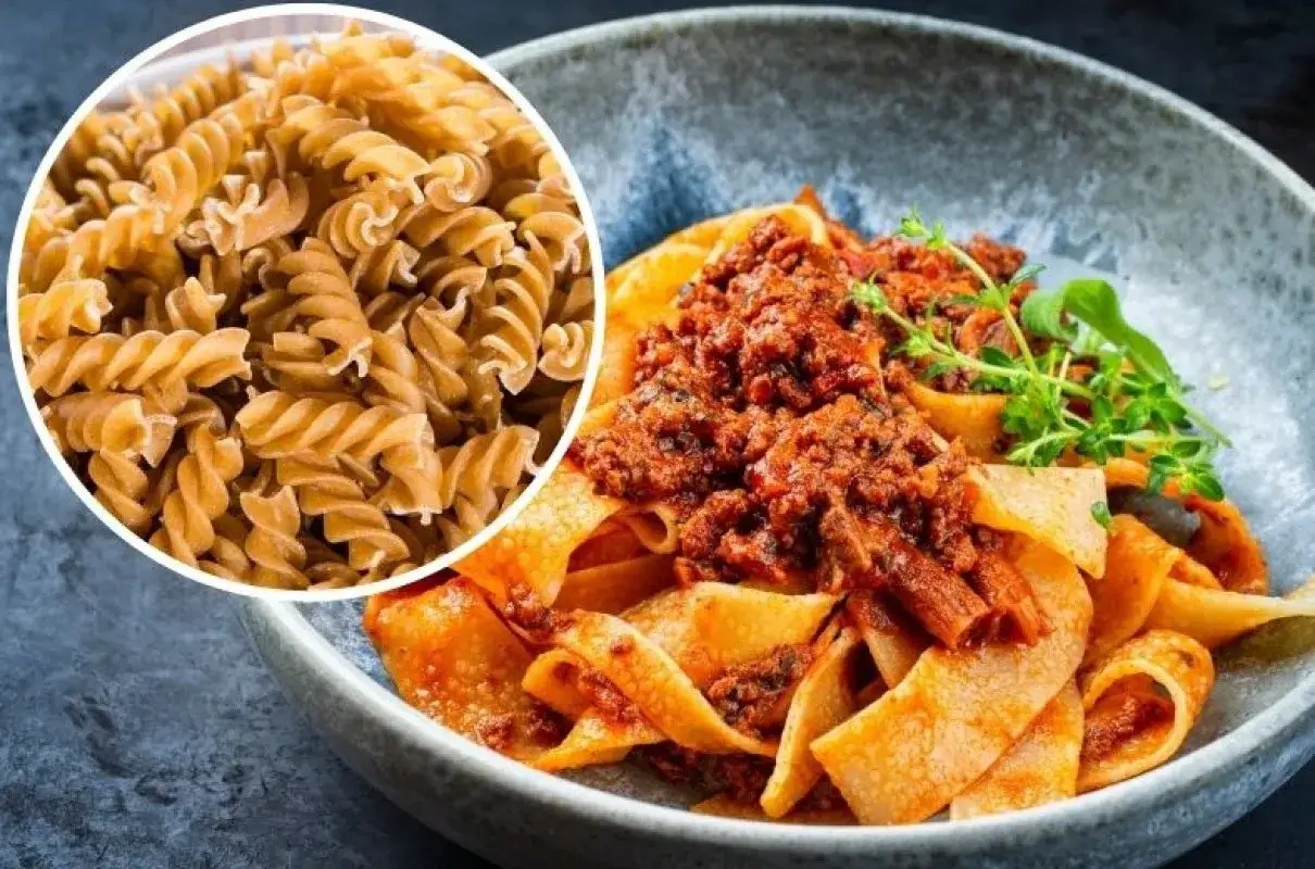 Pyszny makaron na redukcji z sosem bolognese. Widać też surowy makaron fusilli, idealny do zdrowych posiłków.