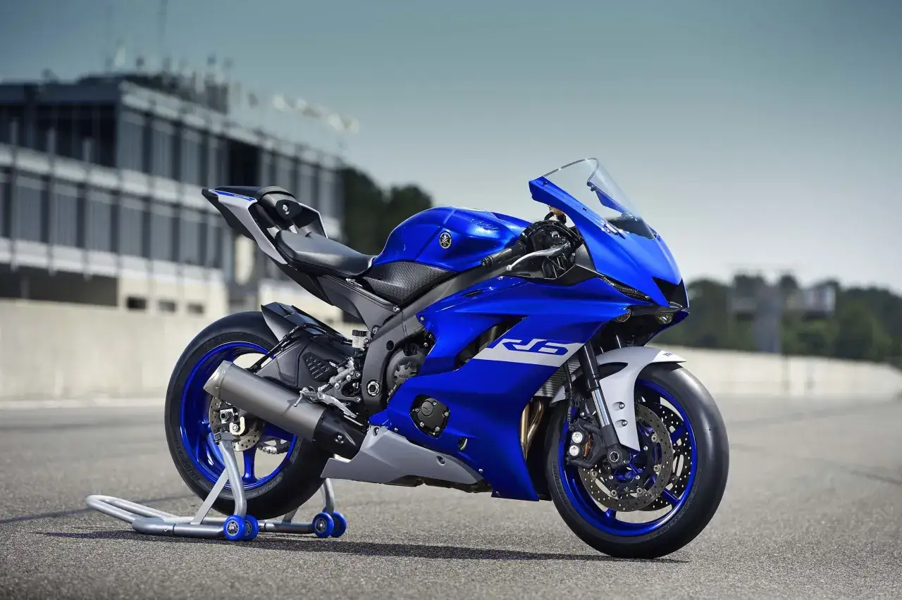 Niebieski motocykl sportowy Yamaha YZF R6 na torze wyścigowym, gotowy do akcji.