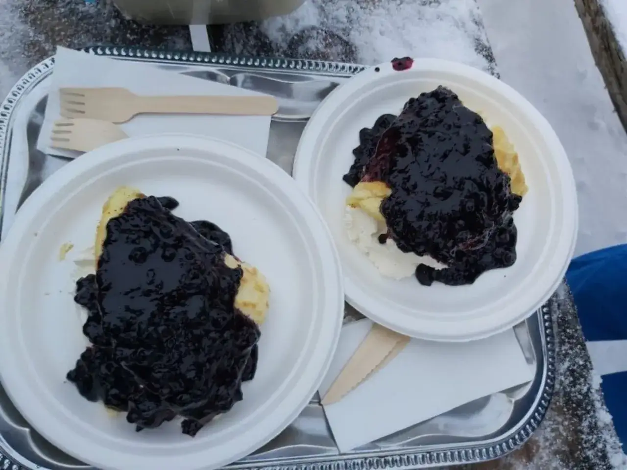 Dwa talerze z naleśnikami i jagodami, gotowe do zjedzenia w górskiej chatce.