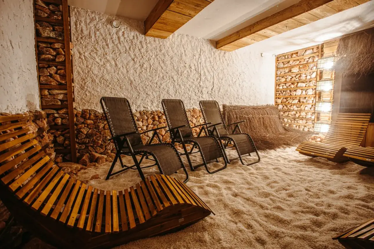 Wnętrze groty solnej z leżakami i kamiennymi ścianami.