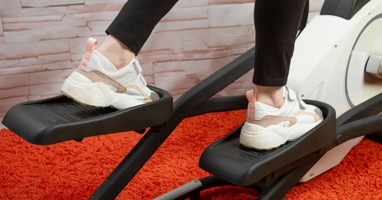 Osoba ćwiczy na orbitreku, który jest dobrym wyborem dla kręgosłupa.