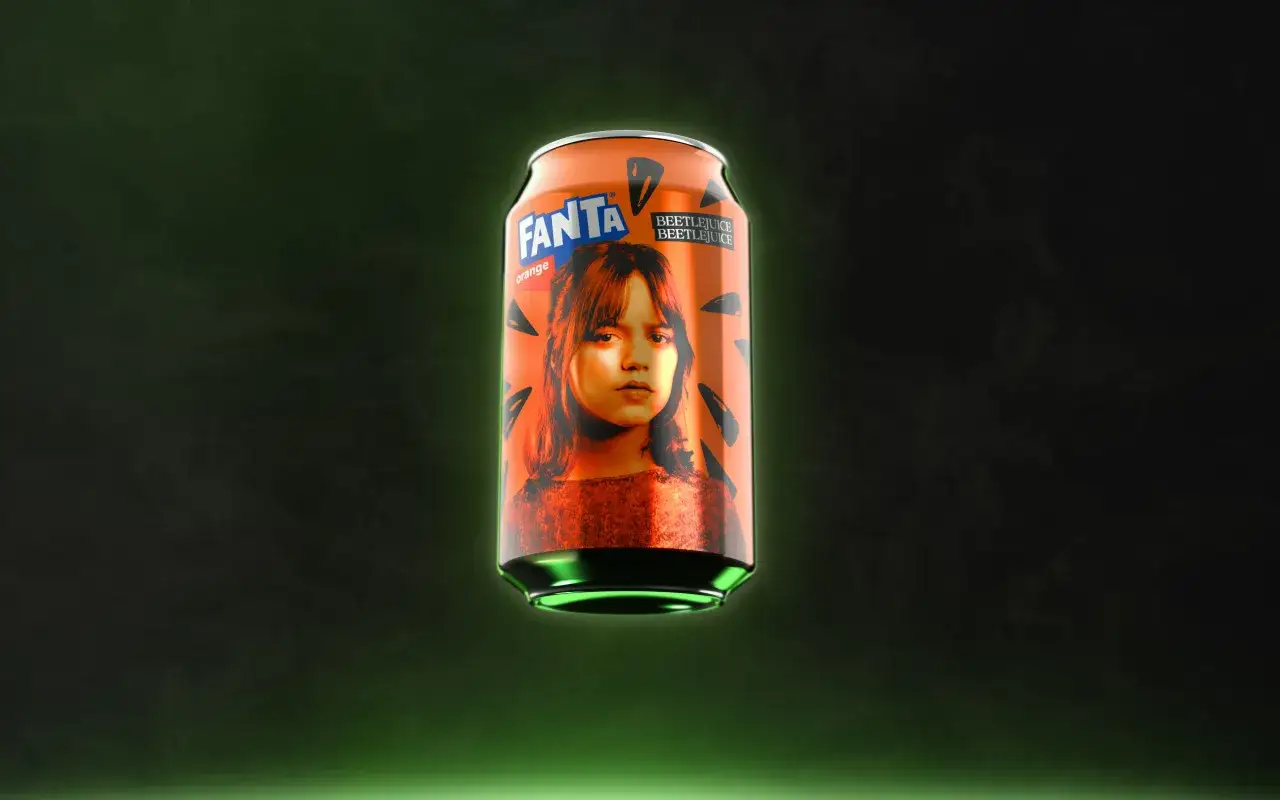 Pomarańczowa puszka Fanta z wizerunkiem dziewczyny i napisem Beetlejuice na ciemnym tle.