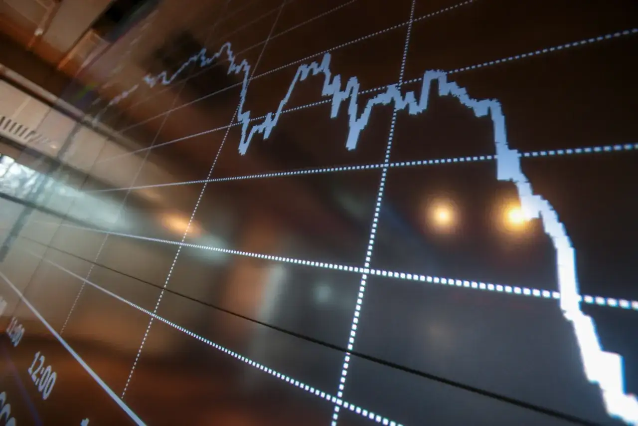 Wykres giełdowy z linią spadkową na ciemnym tle.