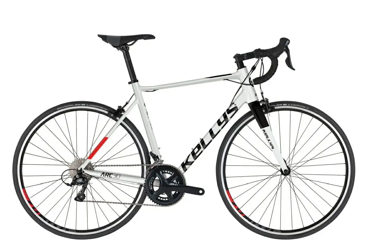 Biały rower szosowy endurance Kellys z czarnymi napisami i czerwonymi akcentami na obręczach. Idealny na długie trasy.
