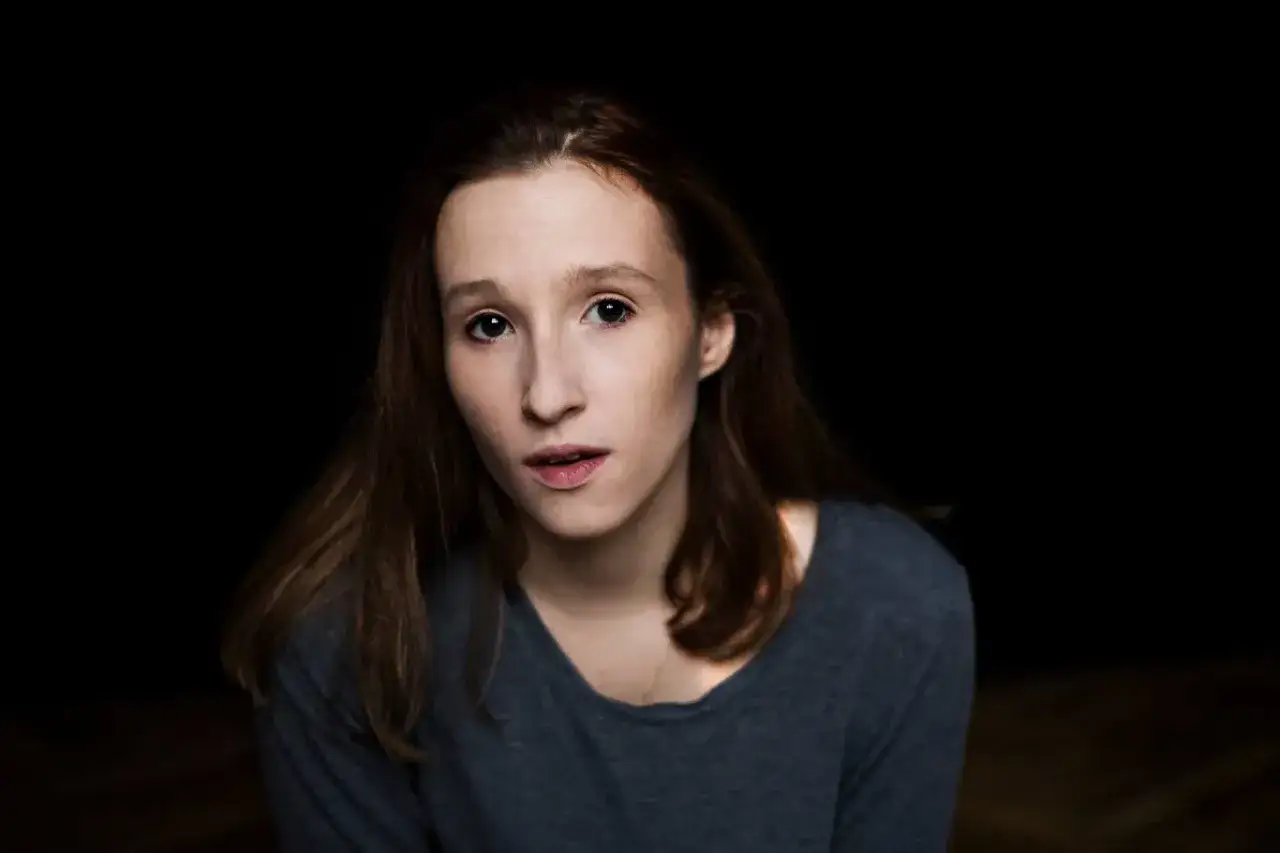 Portret Anny Paligi z ciemnymi włosami i w szarej bluzce, patrzącej wprost przed siebie.