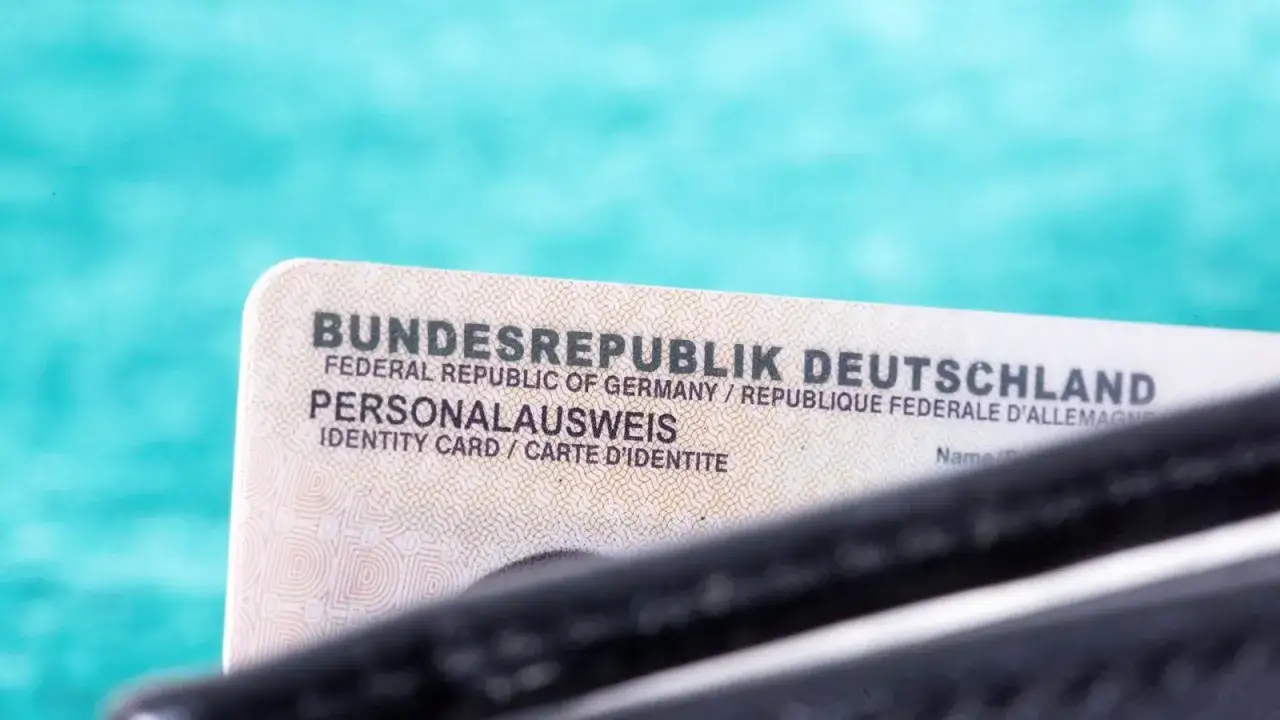 Niemiecki dowód osobisty (Personalausweis) na tle turkusowym.