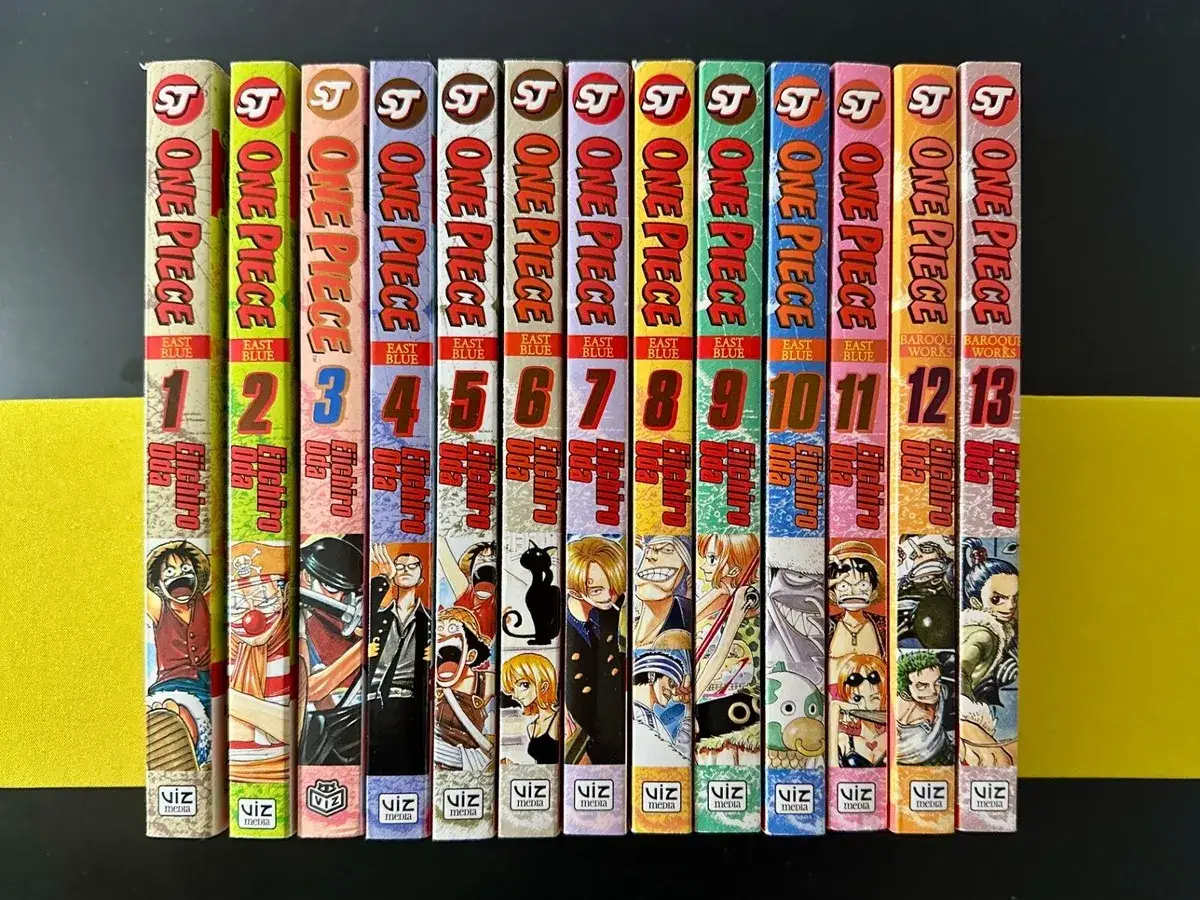 Reihe von 13 One Piece Manga-Bänden, nummeriert von 1 bis 13, mit bunten Cover-Illustrationen.