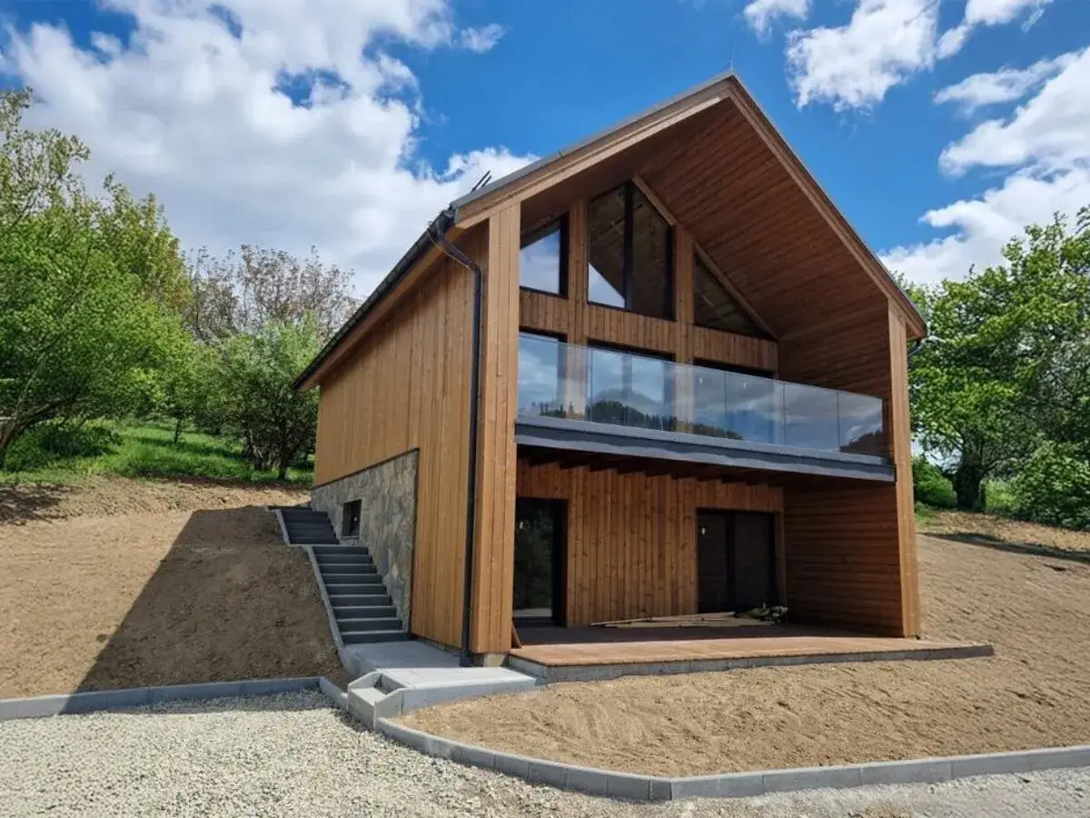 Nowoczesny, drewniany dom modułowy z dużymi oknami i tarasem. Odpowiedź na pytanie: czy domy modułowe są trwałe?