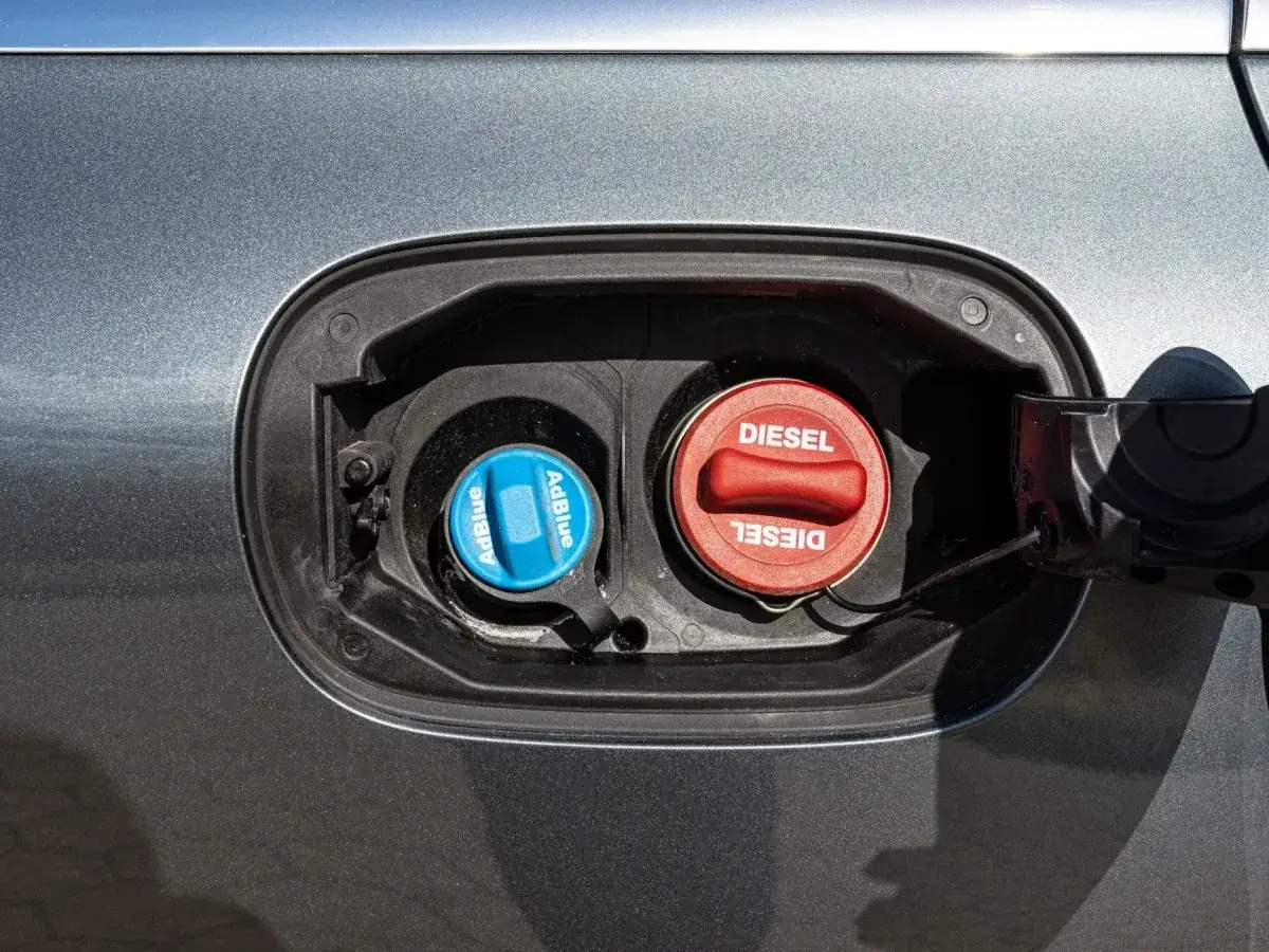 Dwa korki wlewu paliwa samochodu: czerwony z napisem DIESEL i niebieski z napisem AdBlue. To ważne, by wiedzieć, adblue co to jest i gdzie go dolać.