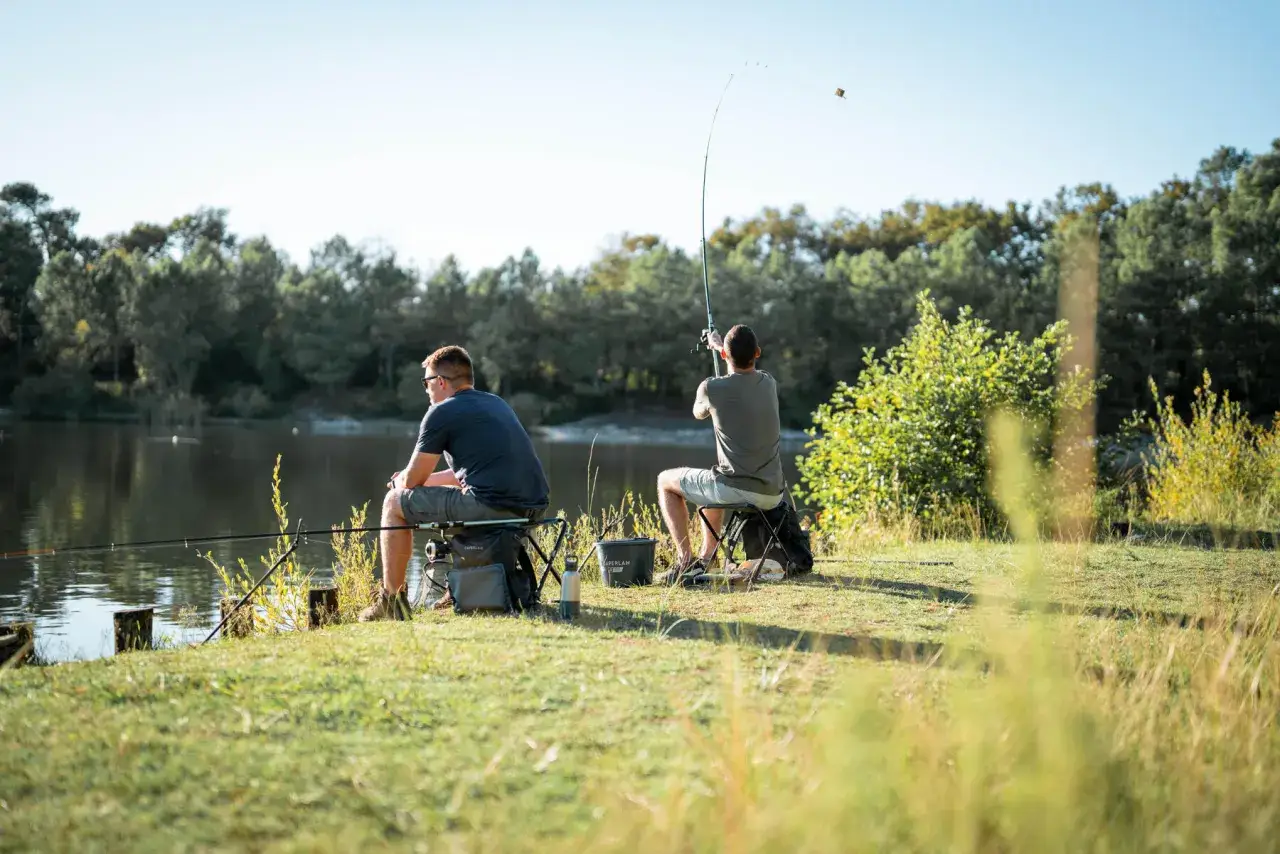 Dwóch mężczyzn łowi ryby nad jeziorem. Idealny dzień na wędkowanie, jak z kalendarza bran otobranie.