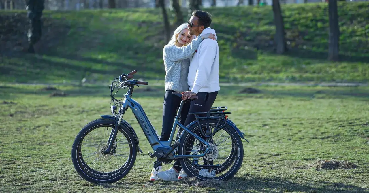 Para zakochanych przy rowerze elektrycznym z silnikiem centralnym, gotowa na wspólną przejażdżkę po parku.