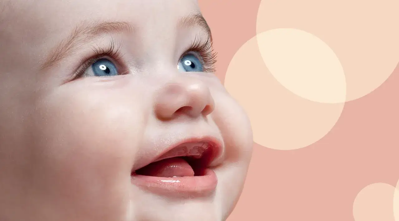 Uśmiechnięta buzia niemowlaka, jak widzi 3 miesięczne dziecko, z niebieskimi oczami i otwartymi ustami, na tle pastelowych kół.