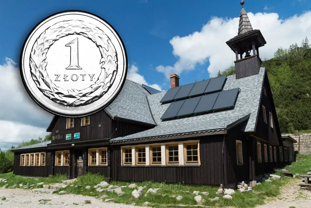Schronisko górskie z panelem słonecznym i monetą 1 złoty.