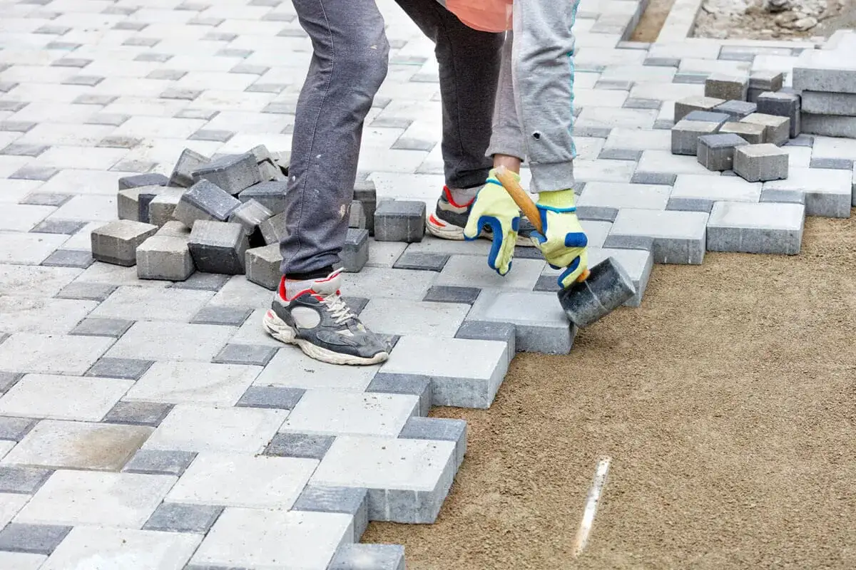 Układanie kostki brukowej na podsypce. Beton pod kostkę tworzy stabilne podłoże dla prac brukarskich.