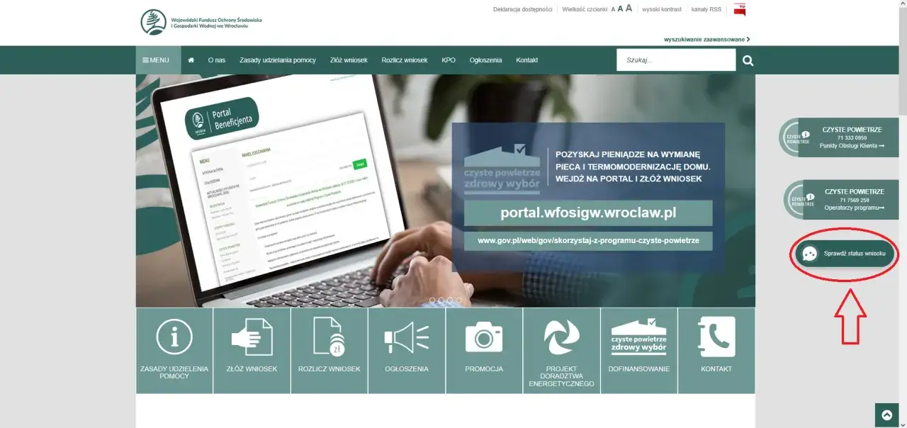 Ręce piszące na laptopie, na ekranie którego widać portal beneficjenta i przycisk "Sprawdź status wniosku".