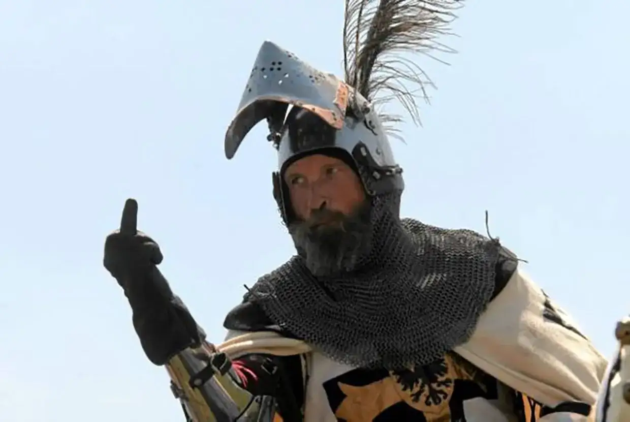 Rycerz w zbroi, przypominający Zbyszka z Bogdańca, pokazuje środkowy palec.