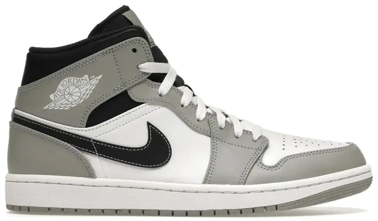 Szary i biały but sportowy, przypominający jordan 1 fake, z czarnym logo i sznurówkami.