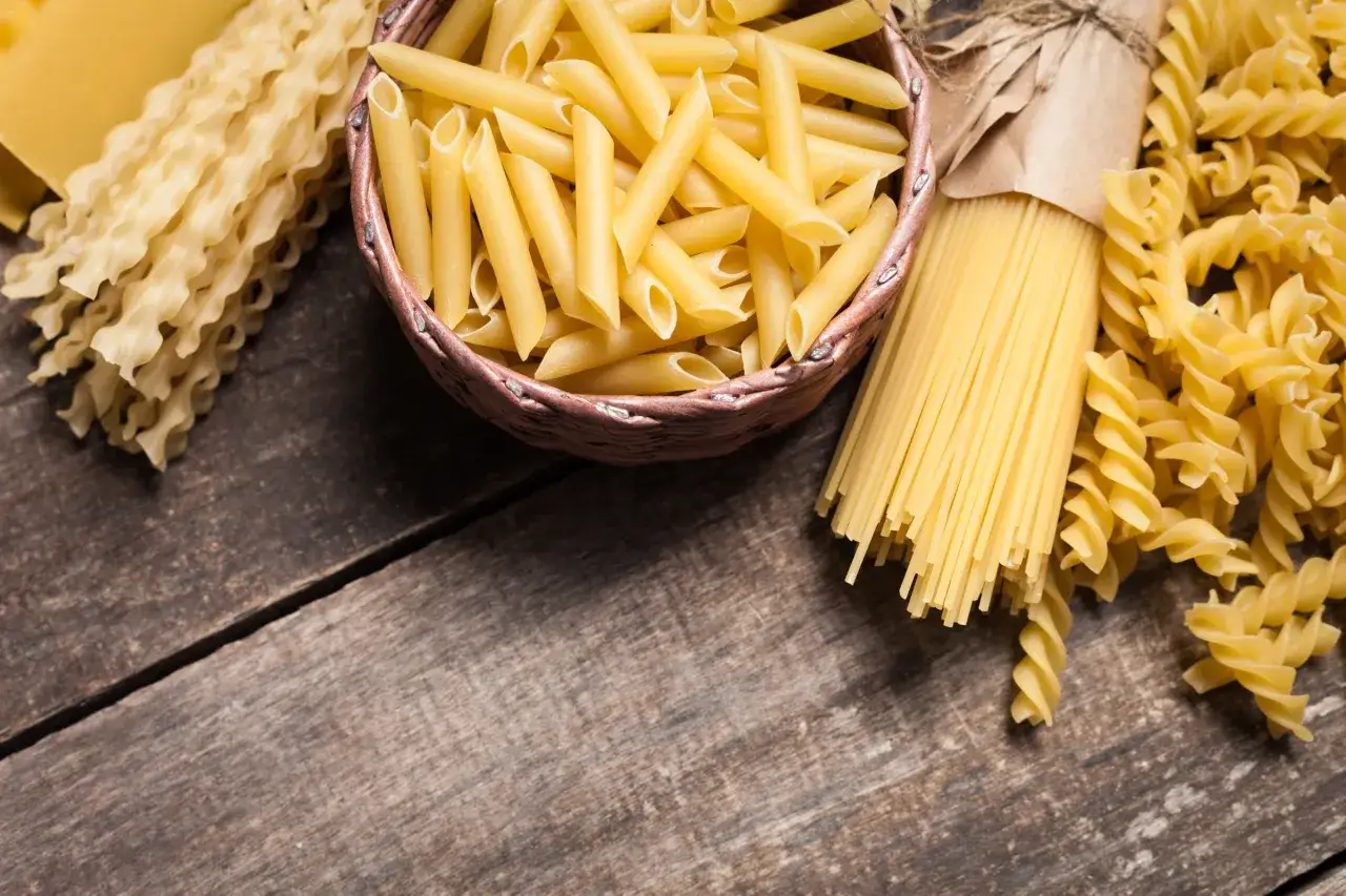 Różne rodzaje makaronu: penne, spaghetti, fusilli i faliste tagliatelle. Wybór między makaronem grahan a durum zależy od preferencji.