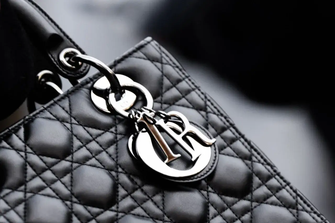 Elegancka, pikowana torebka Lady Dior w kolorze czarnym, z metalicznym logo Dior.