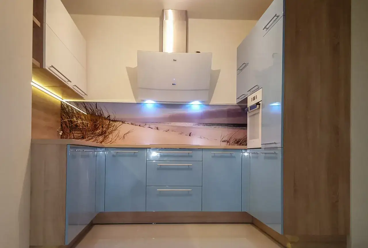 Niebieskie szafki kuchenne z panelem ściennym z plażą i trawą morską. Idealne co na ścianę w kuchni przy kuchence gazowej.