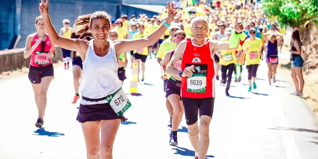 Uśmiechnięci biegacze na maratonie, radość i determinacja. Jak przygotować się do maratonu? Warto czerpać inspirację z ich pozytywnej energii!