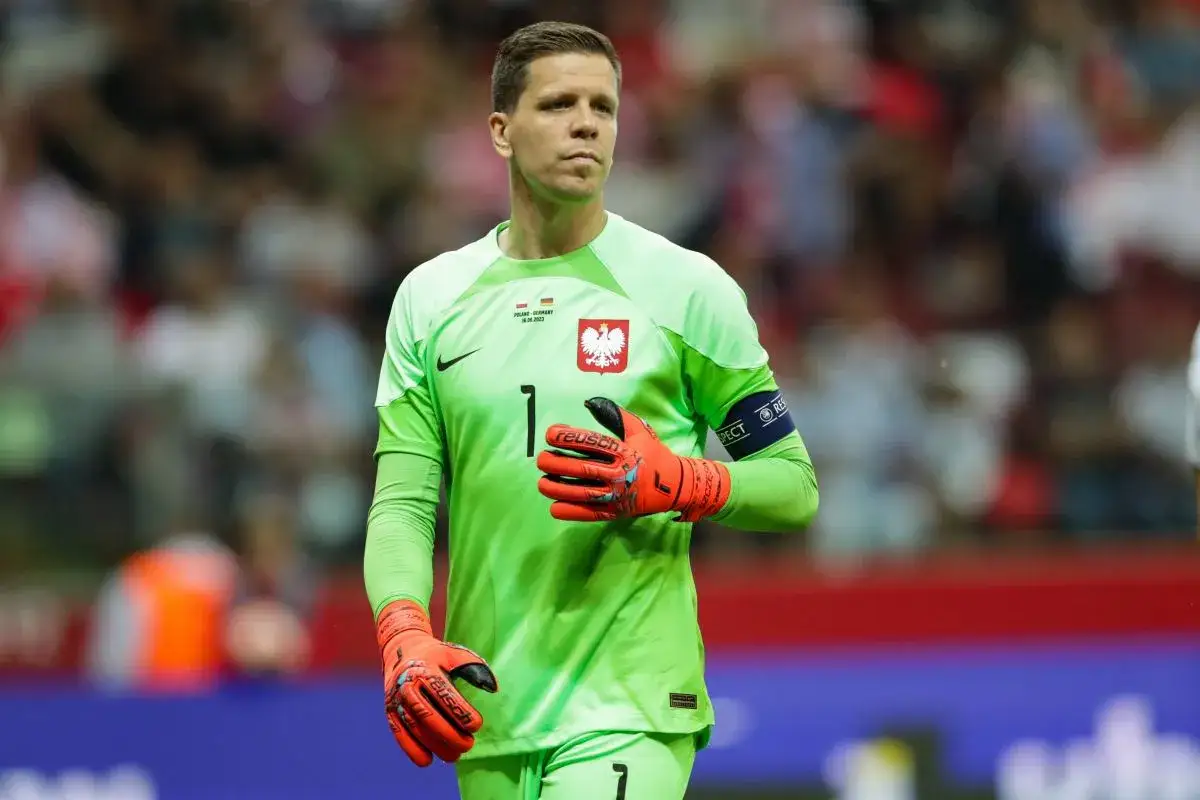 Wojciech Szczęsny, bramkarz reprezentacji Polski, w zielonej koszulce i pomarańczowych rękawicach. Jego imponujący wzrost pozwala mu skutecznie bronić.