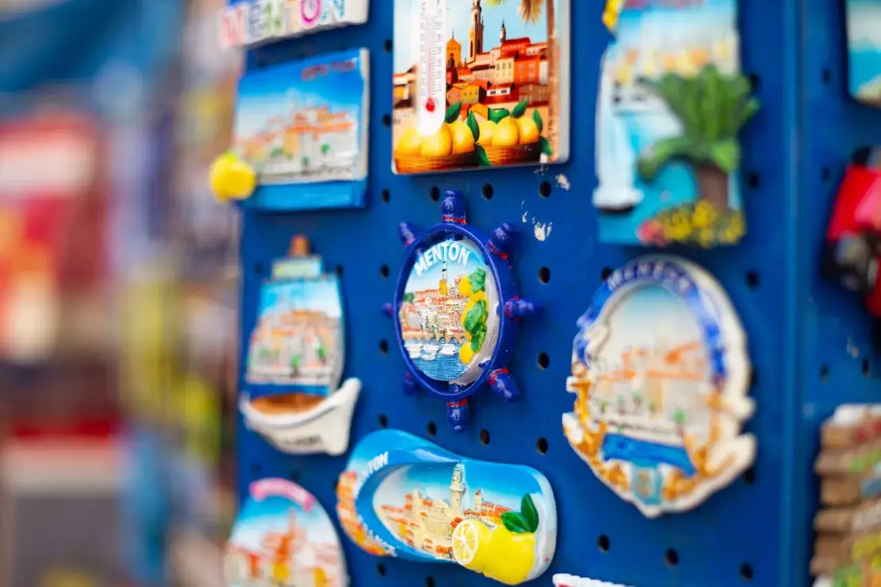 Kolekcja pamiątek z Francji: magnesy z widokami Menton, cytrynami i palmami.