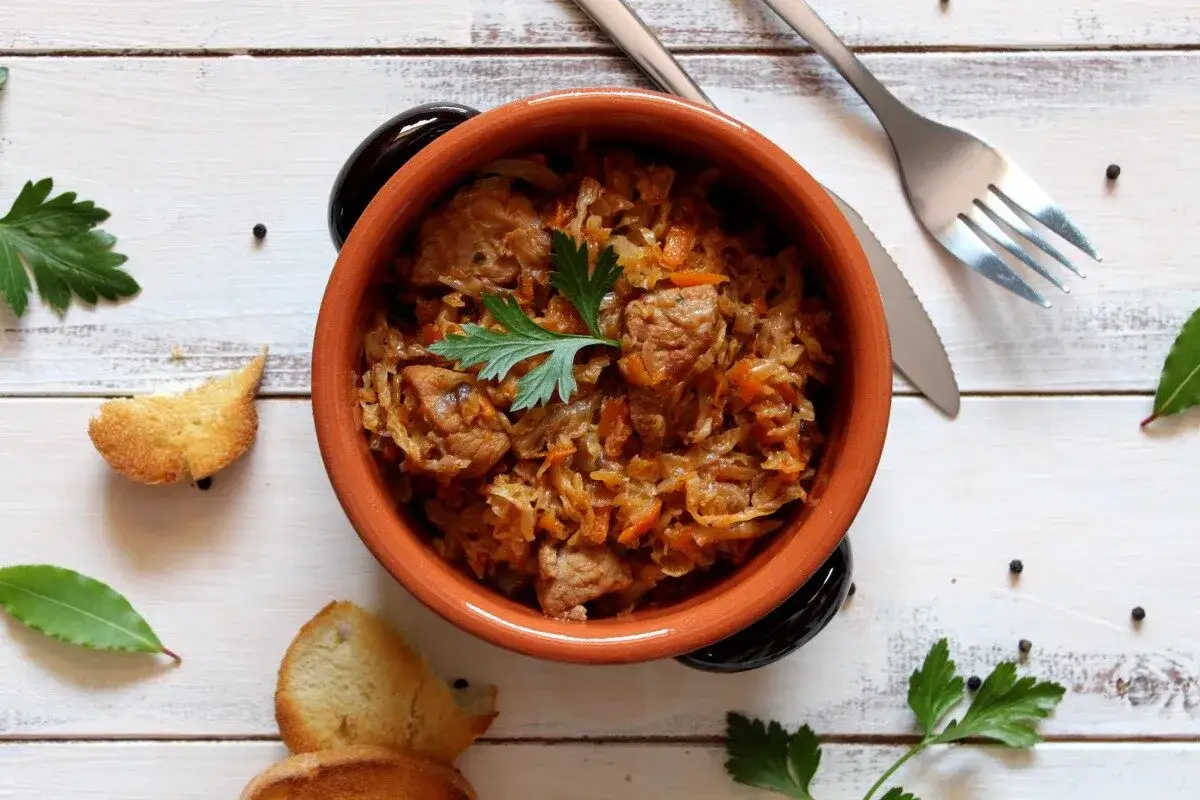 Aromatyczny bigos w glinianym naczyniu, z dodatkiem ziół i pieprzu. Idealne jakie przyprawy do bigosu.