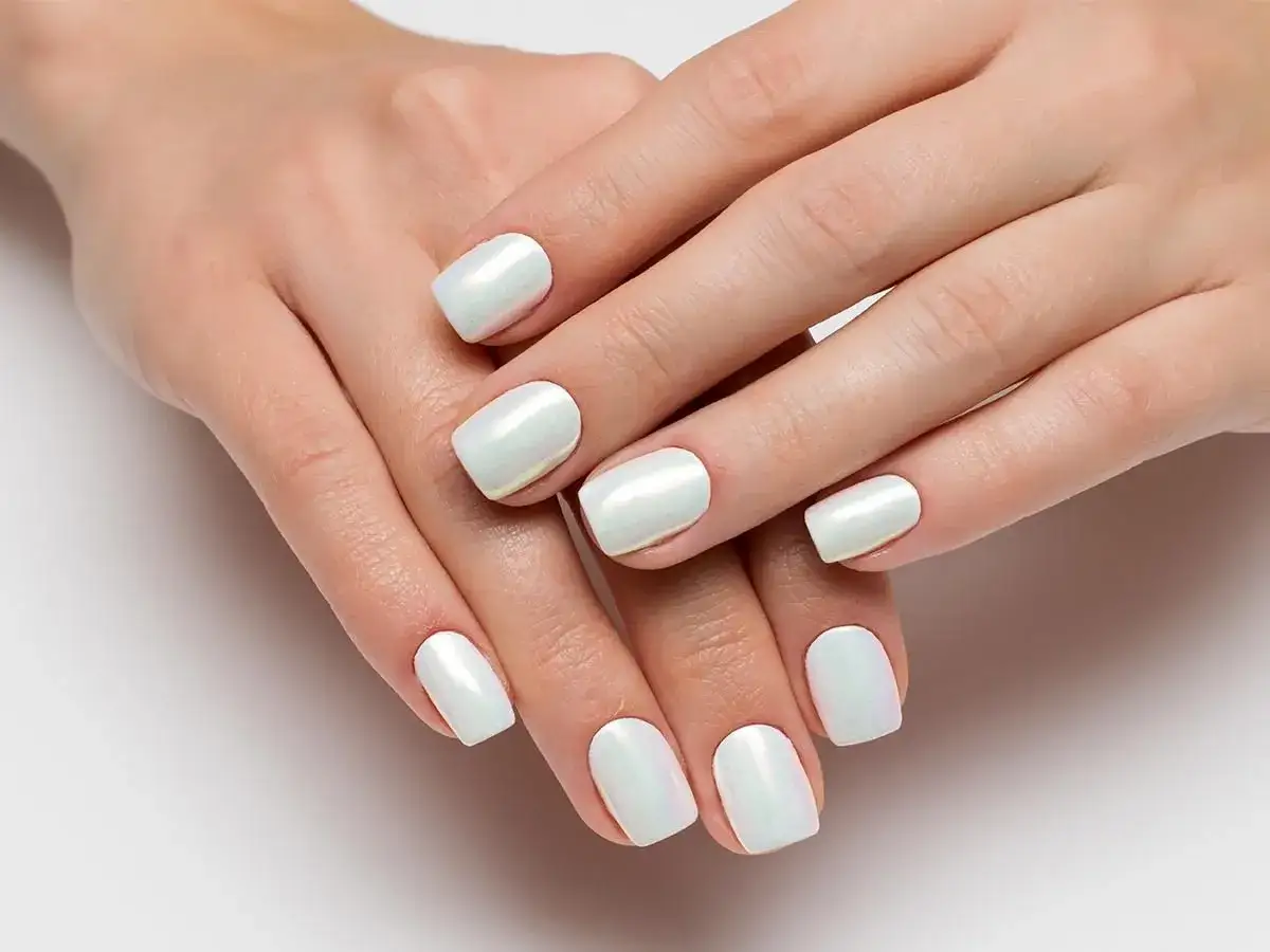 Dłonie z perłowymi paznokciami. Dowiedz się, jak nakładać pyłek na paznokcie, by uzyskać taki efekt.