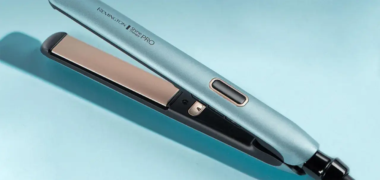 Niebieska prostownica Remington Shine Therapy PRO z złotymi płytkami na jasnoniebieskim tle.
