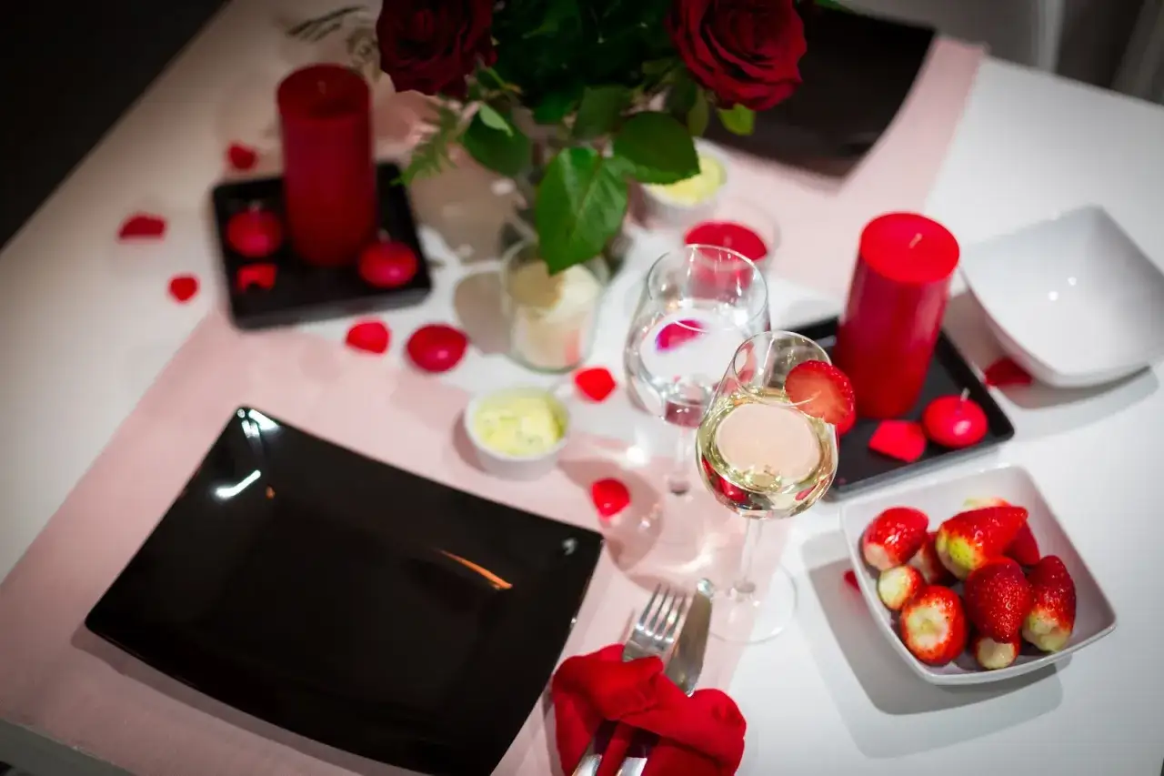 Romantyczna kolacja walentynkowa: czerwone róże, świece, wino i truskawki. Idealne inspiracje, co ugotować na walentynki.