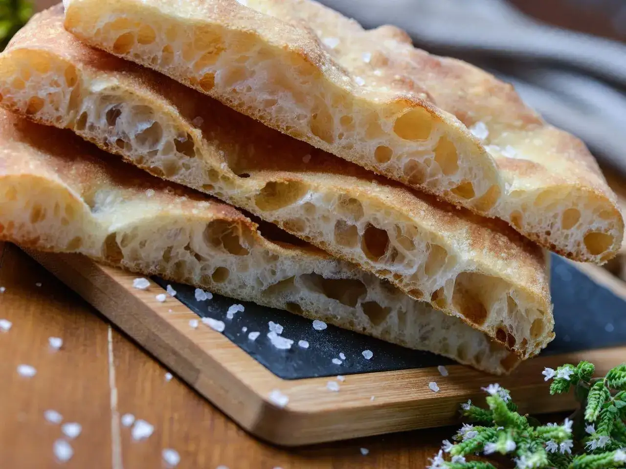 Puszysta focaccia z chrupiącą skórką, posypana solą. Idealny przepis na domową focaccię.