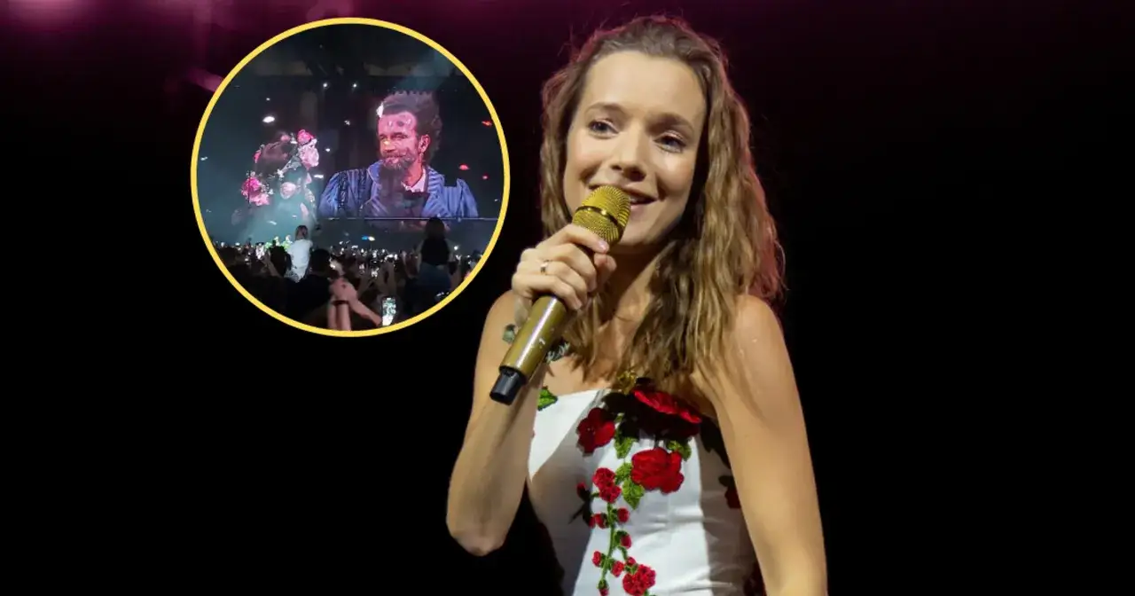 Uśmiechnięta artystka z mikrofonem, a w tle na ekranie widać mężczyznę, który śpiewa kawka na wynos.