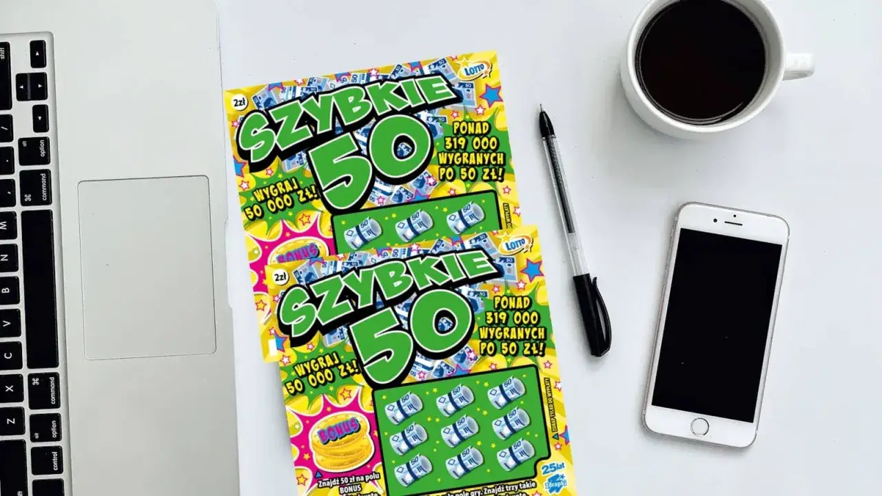 Dwie zdrapki "Szybkie 50" leżą obok laptopa, telefonu i kawy. Czyżby zdrapka jest wygrana?