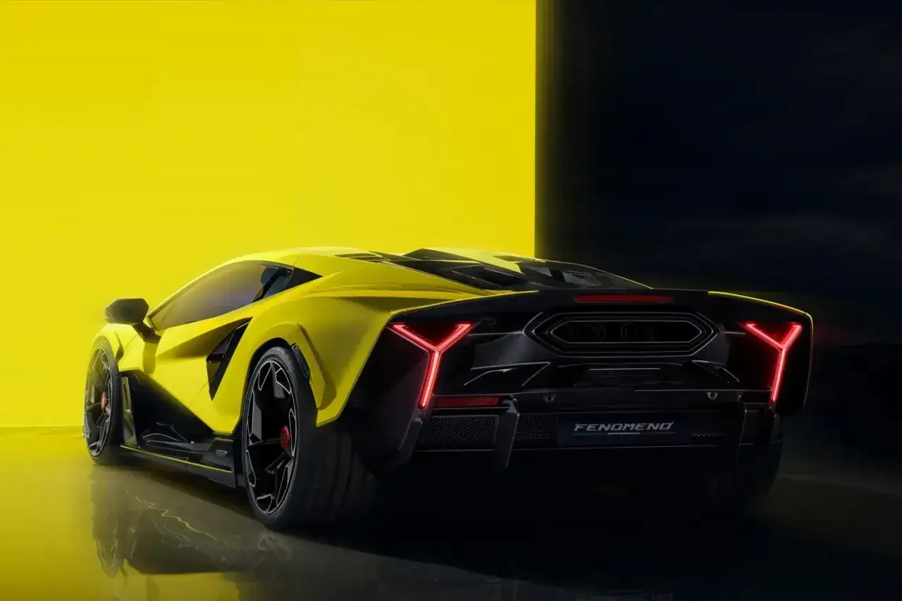 Żółte Lamborghini z ostrymi światłami LED na tle żółtej i czarnej ściany.