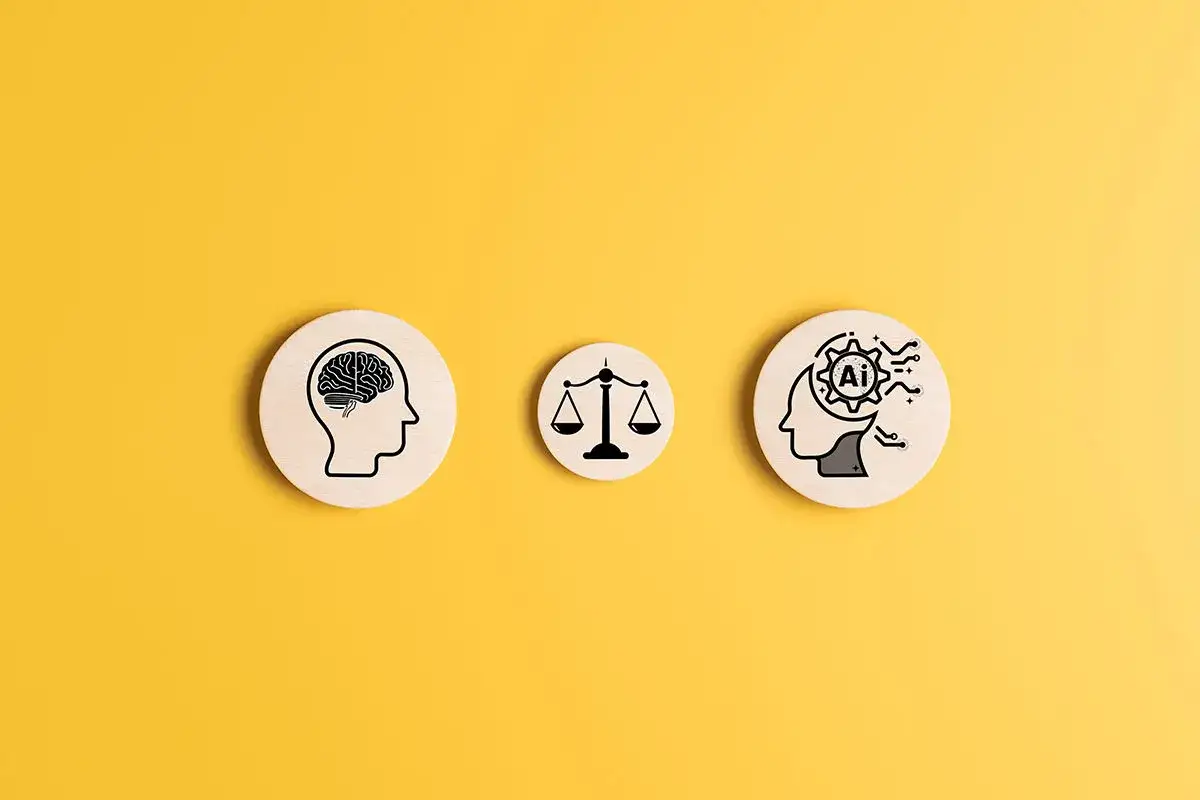 Trzy drewniane krążki na żółtym tle: ludzki mózg, waga sprawiedliwości i głowa z symbolem AI w środku, ilustrują, jak sztuczna inteligencja może rozwiązać dylematy etyczne.