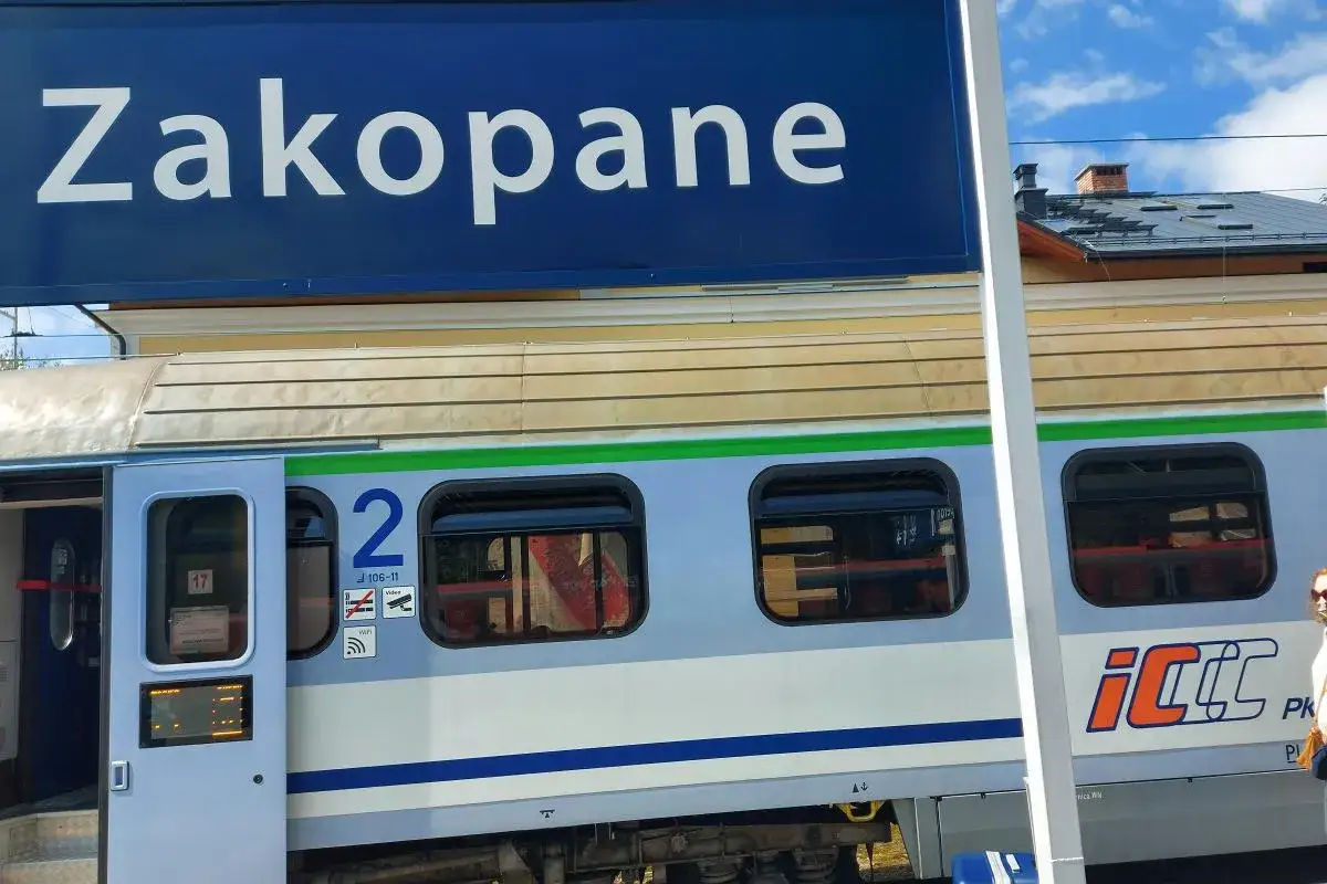 Niebieski znak "Zakopane" nad pociągiem PKP Intercity z numerem wagonu 2.