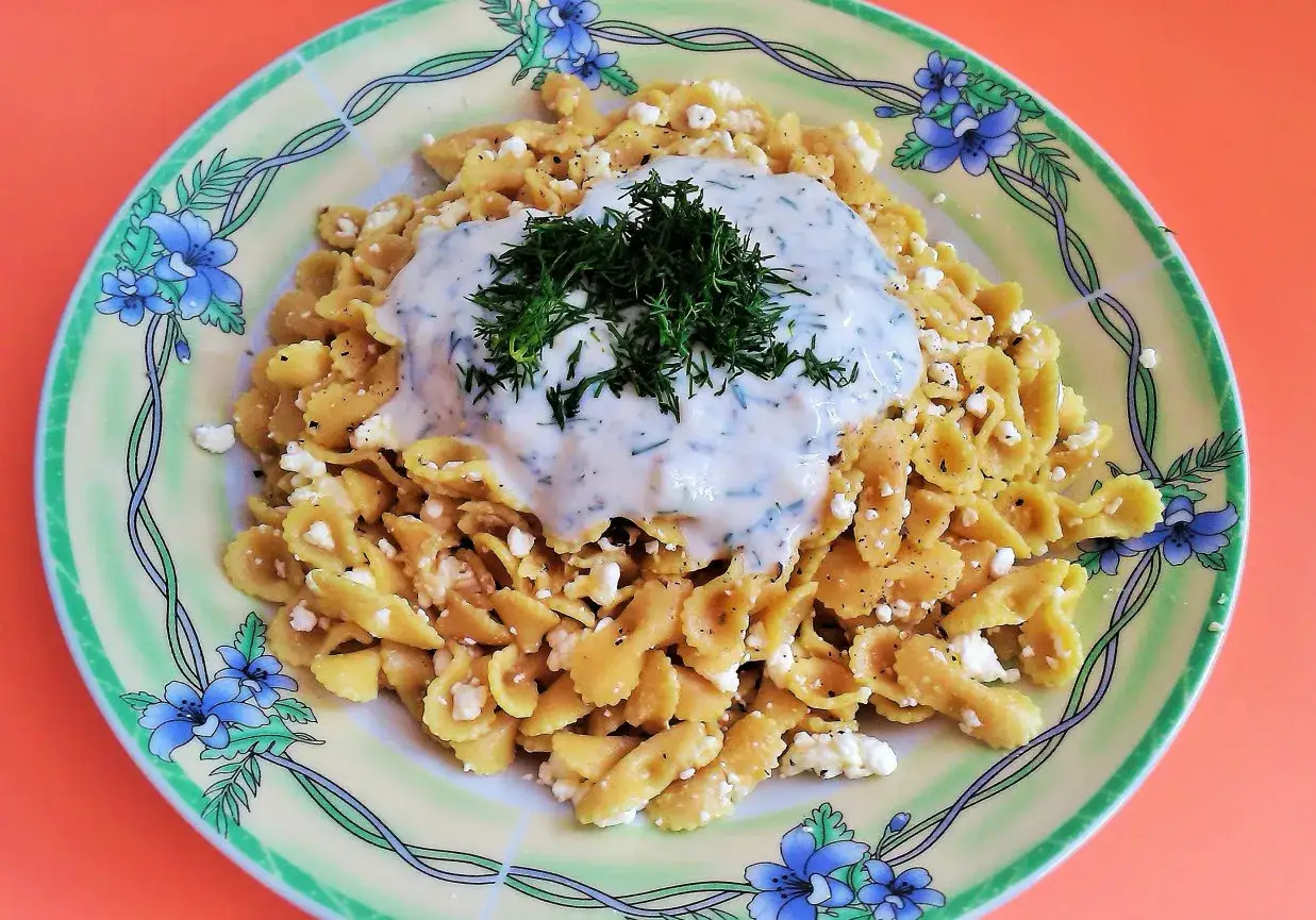 Pyszny makaron z serem, polany kremowym sosem i posypany świeżym koperkiem. Idealny na szybki obiad.