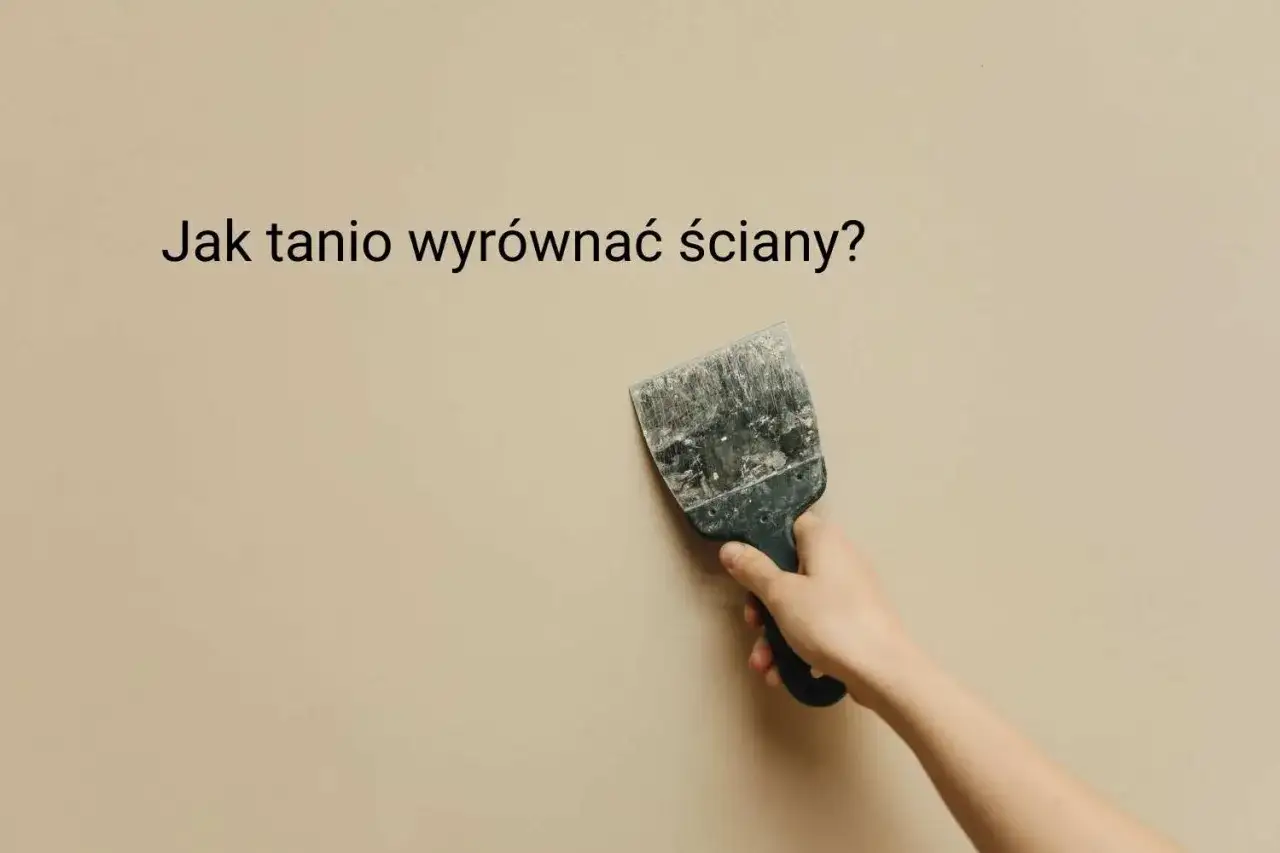 Ręka trzyma szpachelkę przy beżowej ścianie, szukając pomysłu na krzywe ściany.