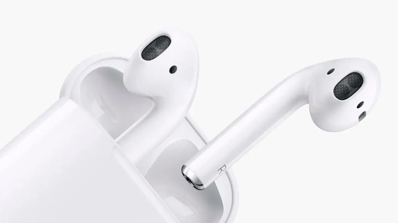 Białe słuchawki AirPods w etui. Dowiedz się, jak sprawdzić ile AirPods mają baterii, by zawsze cieszyć się muzyką.