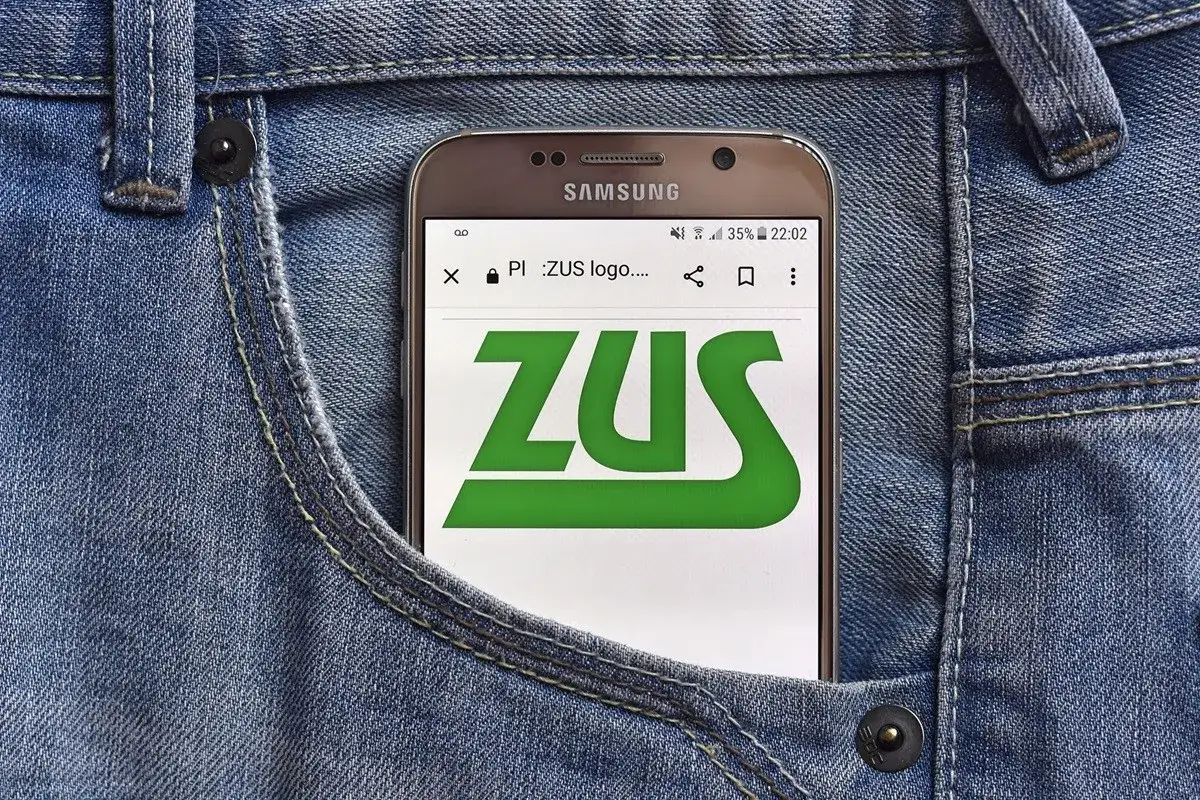 Telefon w kieszeni dżinsów wyświetla logo ZUS. Sprawdź, jak sprawdzić wysokość emerytury w ZUS PUE.