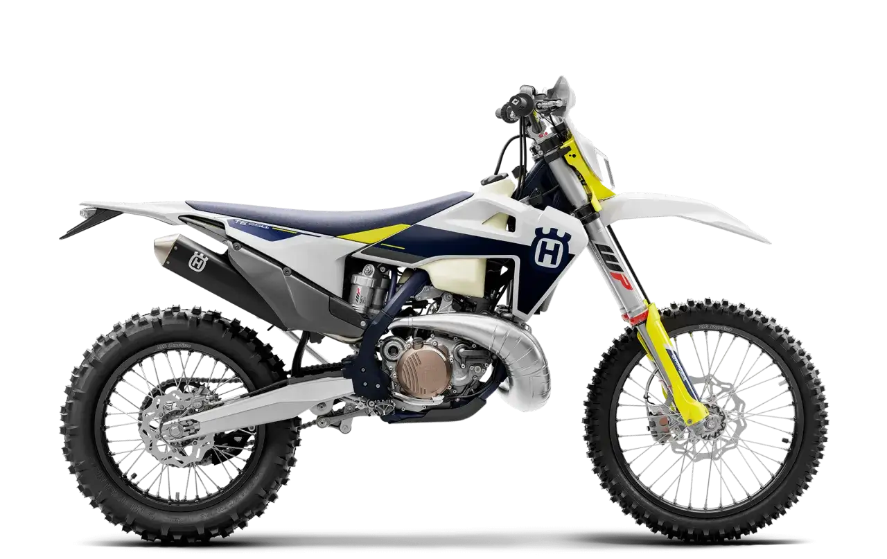 Motocykl Husqvarna TE 250 2T w białej, granatowej i żółtej kolorystyce, widok z boku.