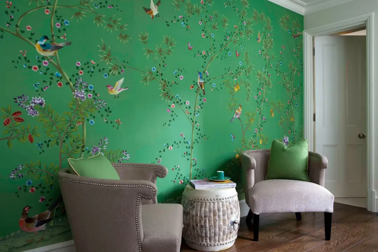 Tapeta zielone kwiaty z ptakami i gałązkami bambusa. Dwa fotele i stolik tworzą przytulny kącik.