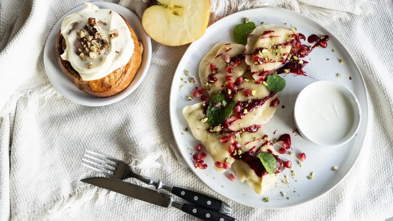 Pyszne pierogi z granatem i pistacjami, słodka bułka z kremem i jabłko. Idealne dobre jedzenie na trasie Warszawa-Lublin.