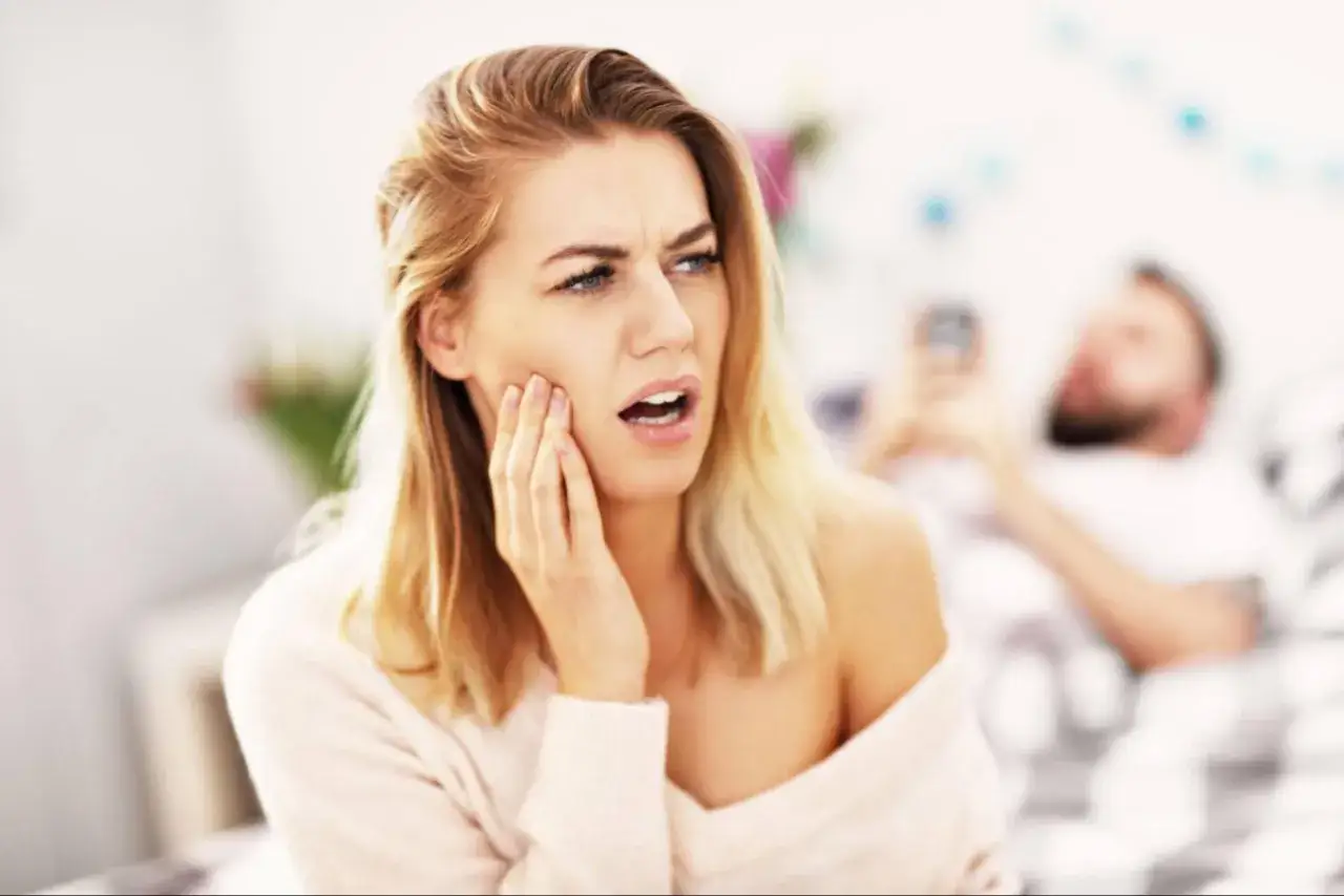 Kobieta z odrętwiałą twarzą po wizycie u dentysty.