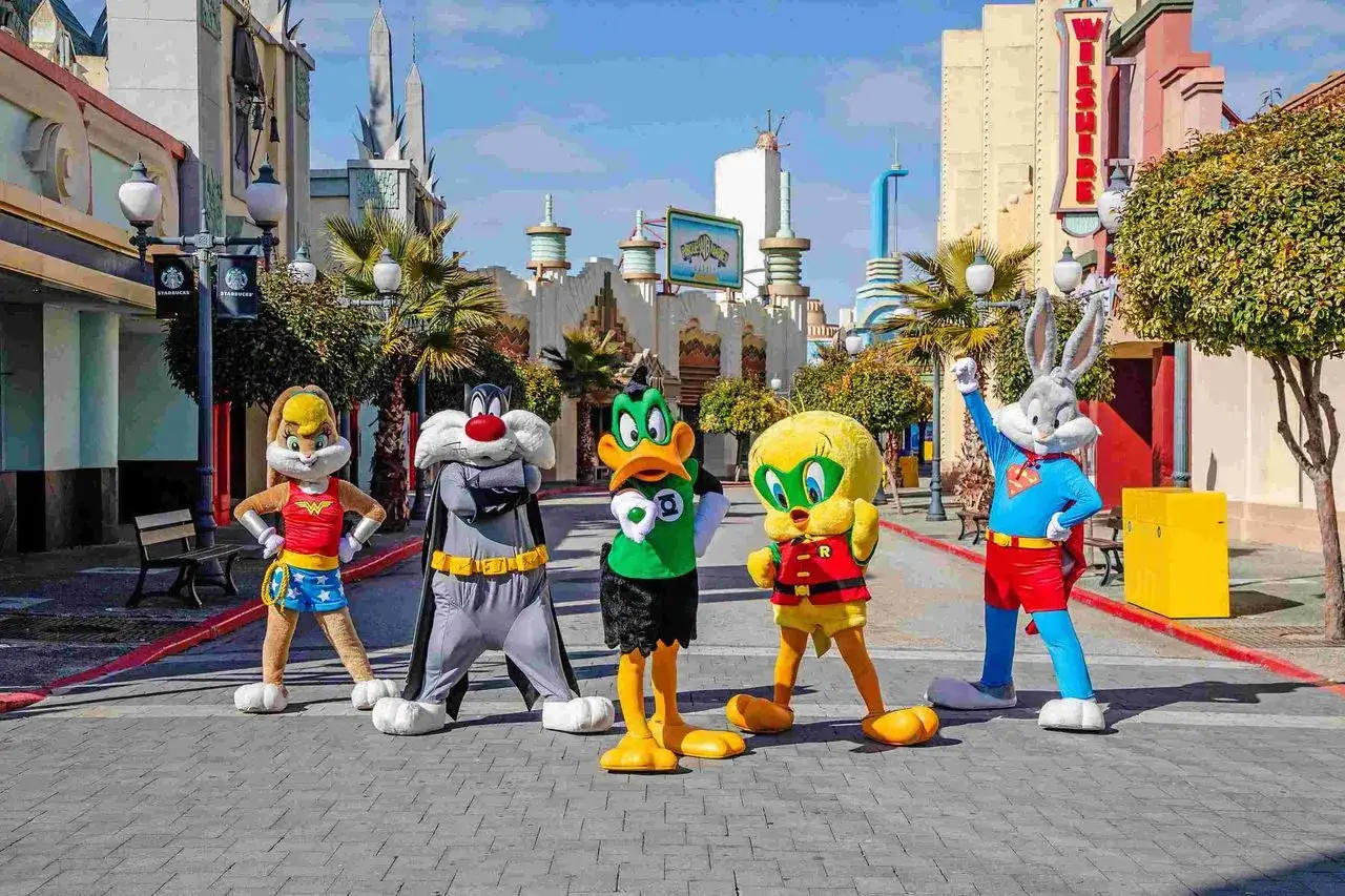 Personajes de Looney Tunes celebran la nueva atracción Warner. Bugs Bunny, Piolín, Silvestre, Lola Bunny y el Pato Lucas posan en la calle.
