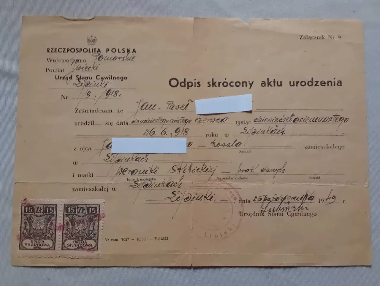 Odpis skrócony aktu urodzenia z pieczątkami i dwoma znaczkami opłaty skarbowej.