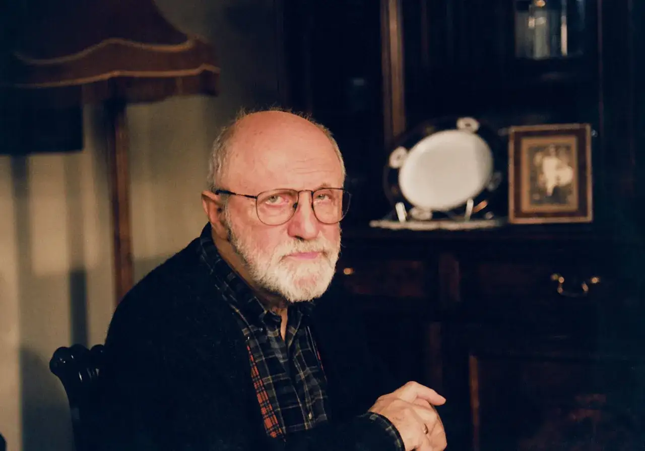 Portret starszego mężczyzny z siwą brodą i okularami. W tle widać meble i ozdobną zastawę. Wiele osób zastanawia się, jak zmarł Henryk Machalica.