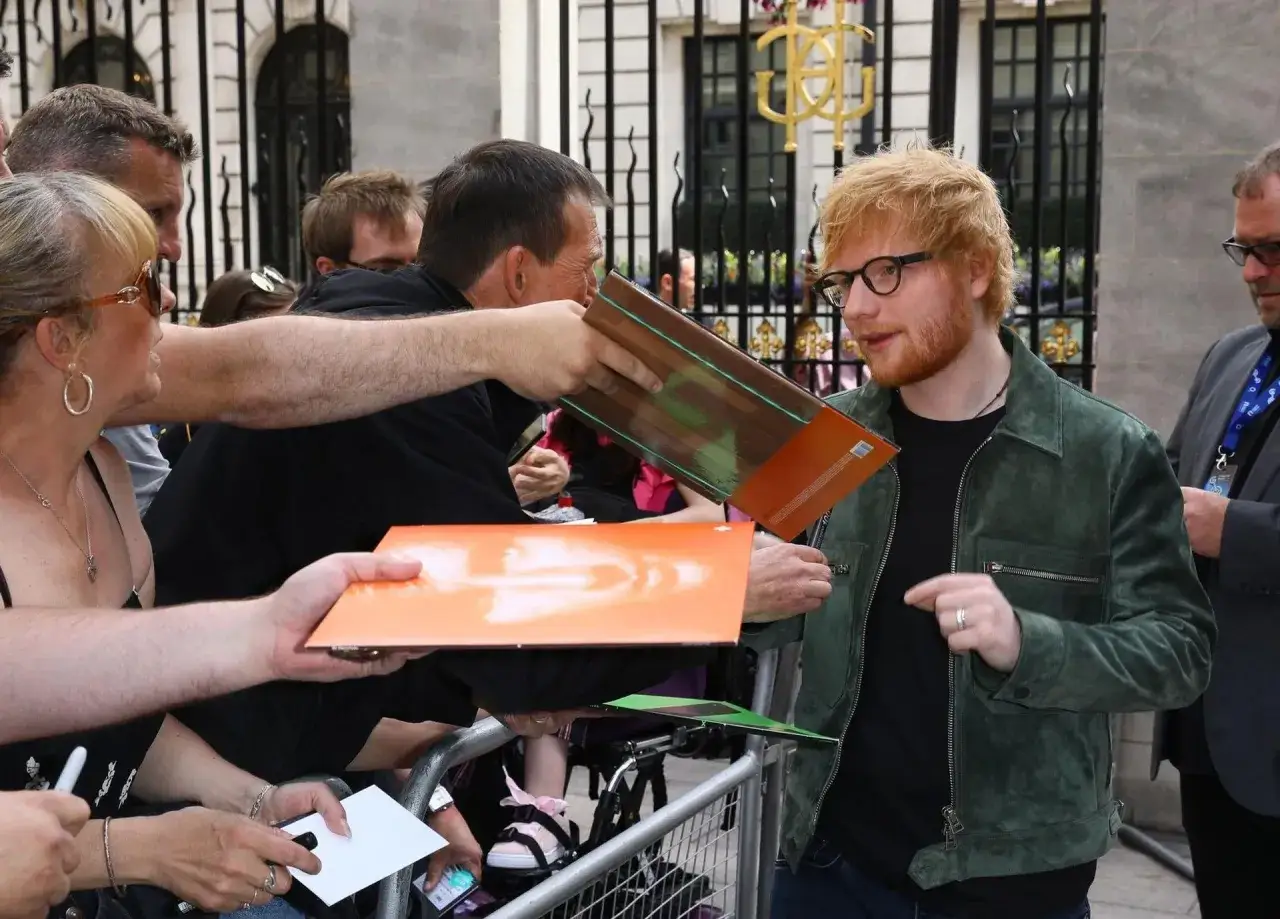 Ed Sheeran rozdaje autografy fanom. Ciekawe, ile zarabia Ed Sheeran, że stać go na tyle płyt!